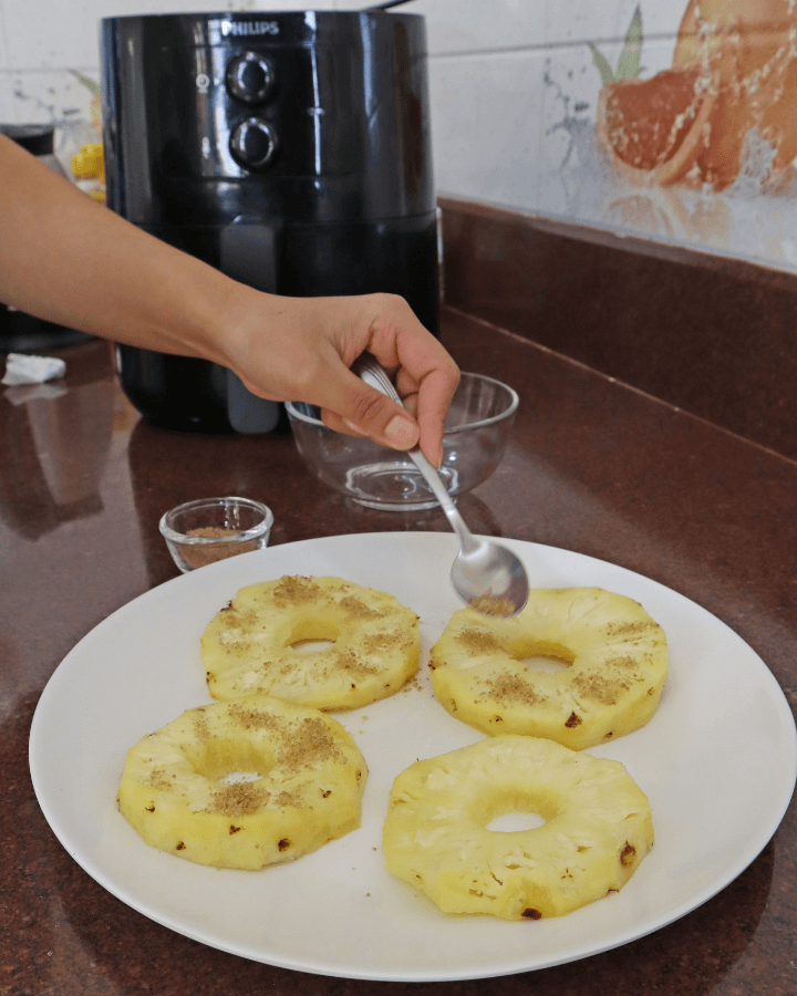 sprinkle spices on pineapple pieces